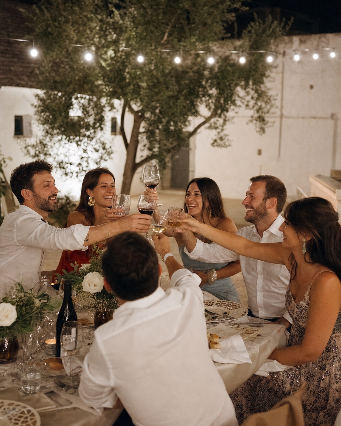 Gruppo di invitati brinda durante una cena di matrimonio